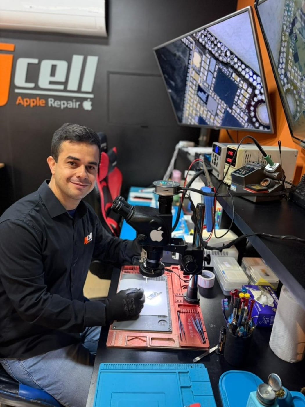 Técnico da NJCELL em laboratório com microscópio para reparo de iPhone em Sorocaba