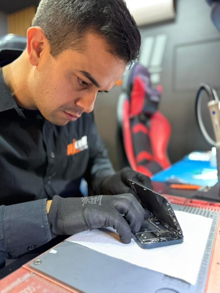 Técnico da NJCELL desmontando iPhone para troca de tela em Sorocaba